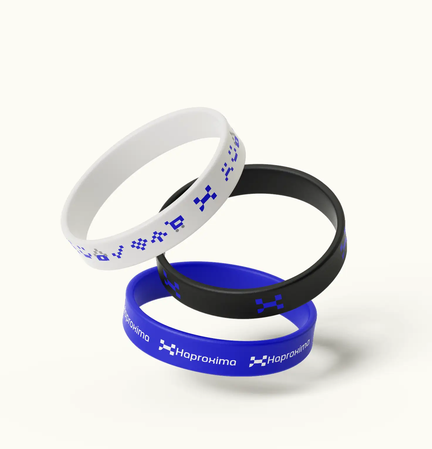 Três pulseiras de silicone: uma azul, uma branca e uma preta, com os elementos da marca Haproxima.